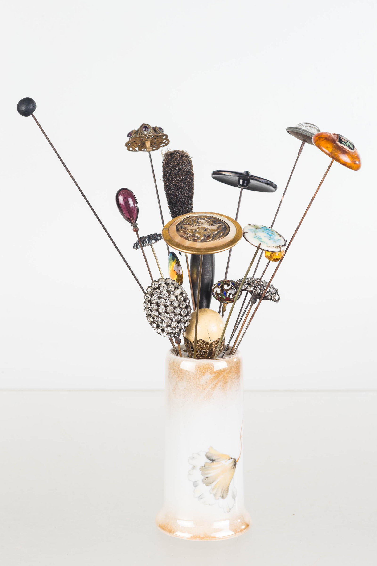 Victorian to Art Nouveau Hat Pins: Lot includes Art Nouveau ca. 1910 carnival glass hat pin, sterling silver lotus flower, several long, large rhinestone, Champleve enamel, large mother of pearl brass cherub, and others. 15 total piece