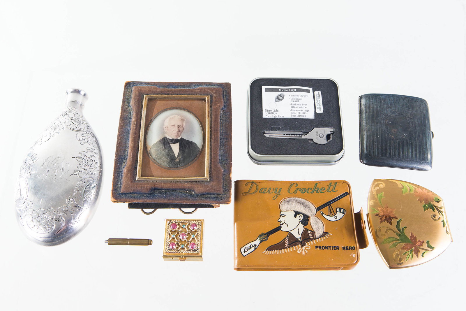 Compacts, a Flask, and Other Items: Lot includes an Elgin American floral compact, silver plated cigarette case, silver plated liquor flask, a hand colored photo of a gentleman, a Davy Crockett wallet and other items.