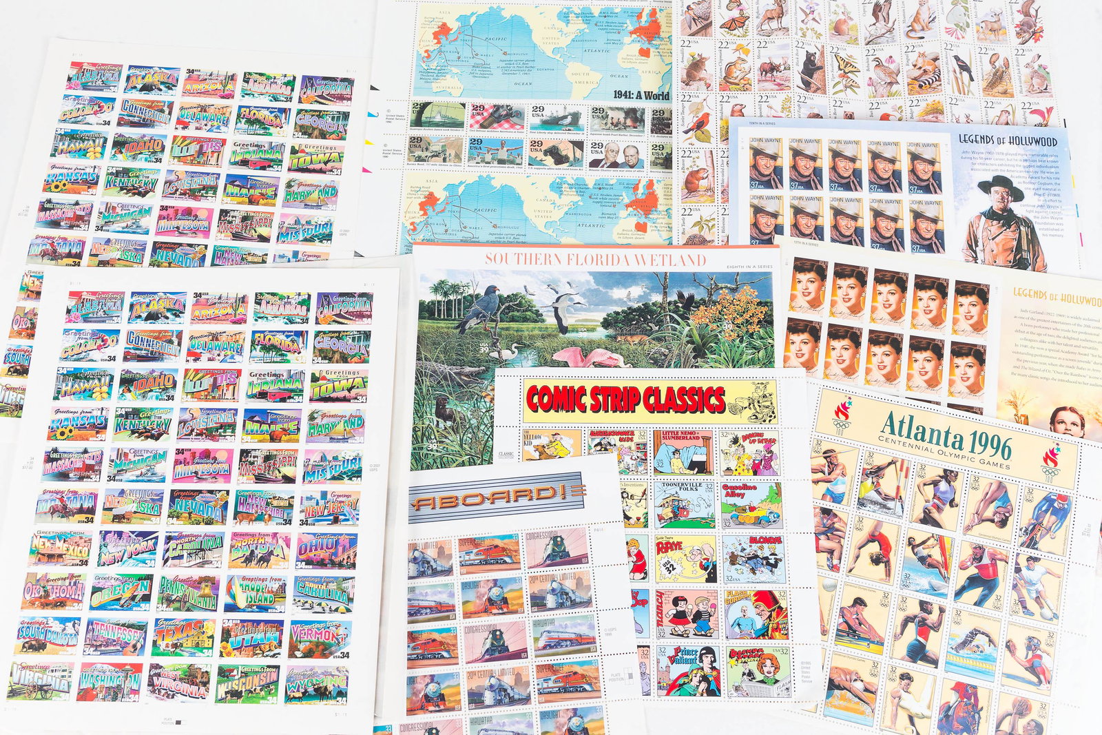 Full Sheet US Postage Stamps: Lot includes 10 full sheets, including Railroad 33c, Comic Strip Classics 32c, Atlanta Olympics 32c, Judy Garland 39c, State Stamps 34c, and others.