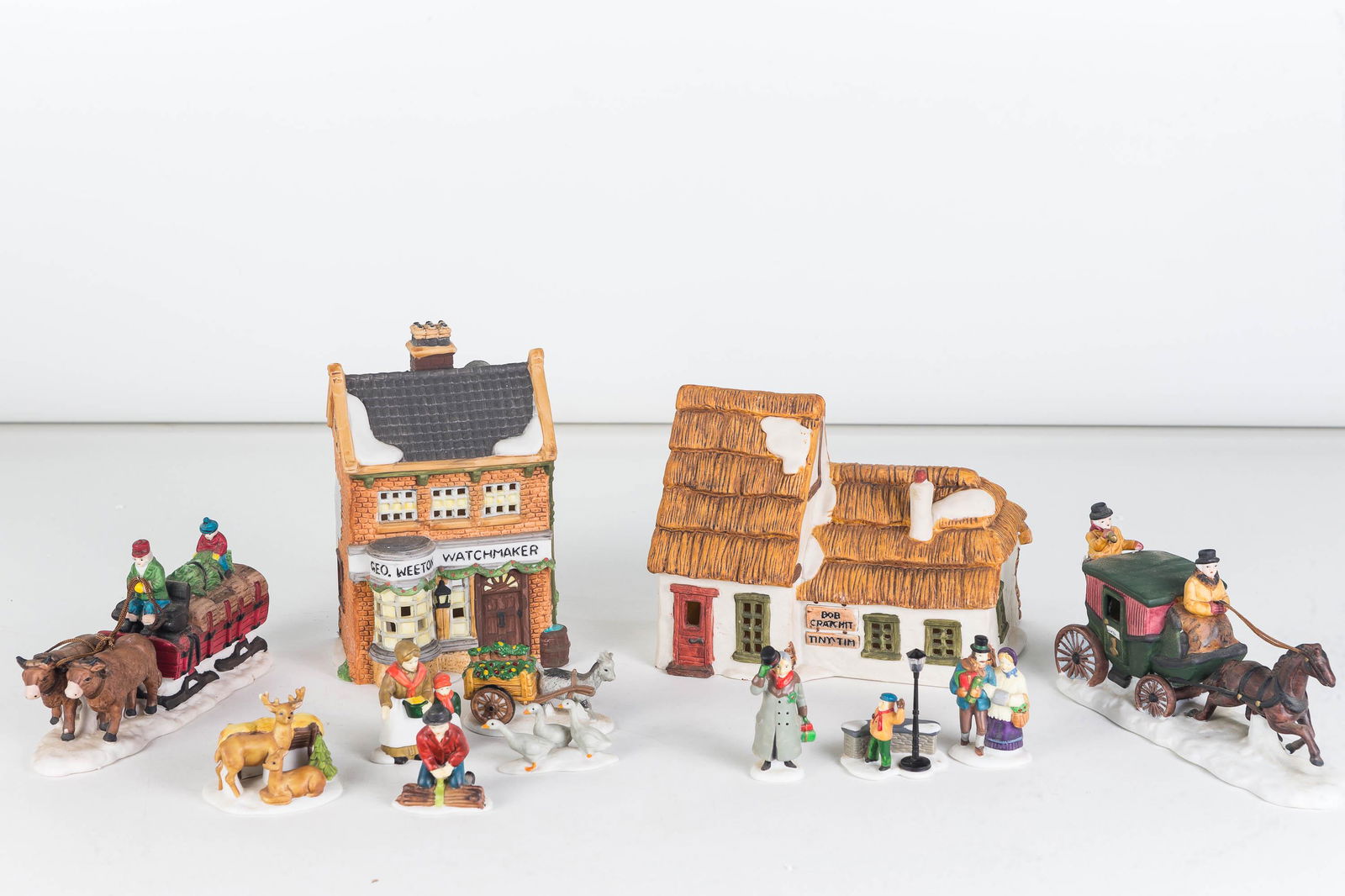 Studio 56 Dickens Village Collection: Lot includes 6 pieces including Geo Weeton Watchmaker, Ox Sled, A Christmas Carol 3-piece Set, Christmas Carol Morning 3-piece set, horse with coach, and farm people and animals.