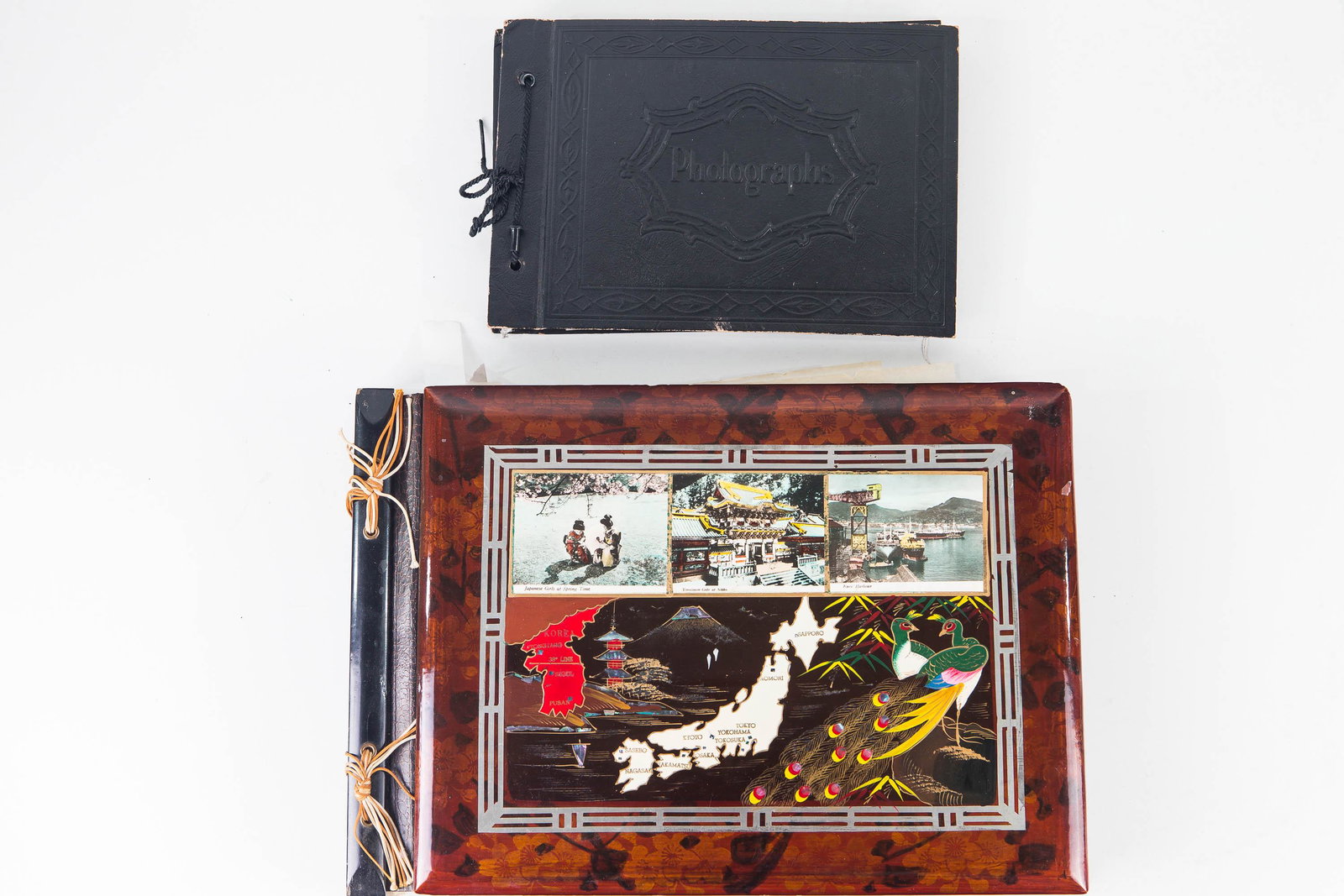 Korean War Photo Albums with Extras: Larger album contains many Korean War photos, including photo of USS General A. E Anderson, three patches, Korean coin and paper money, photos of Buddha statues, Thanksgiving Day photos, and newspaper