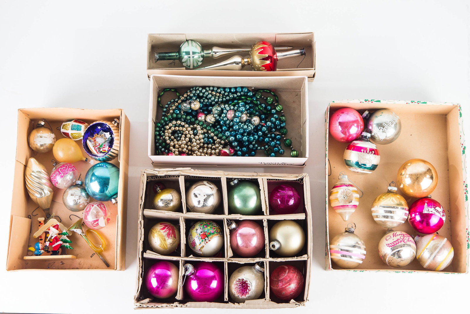 Collection of Christmas Balls/ Toppers: Lot includes a large selection of various Christmas bulbs, including frosted, a horn, recessed bulbs, and others. Lot also includes two tree toppers and various strings of beads.