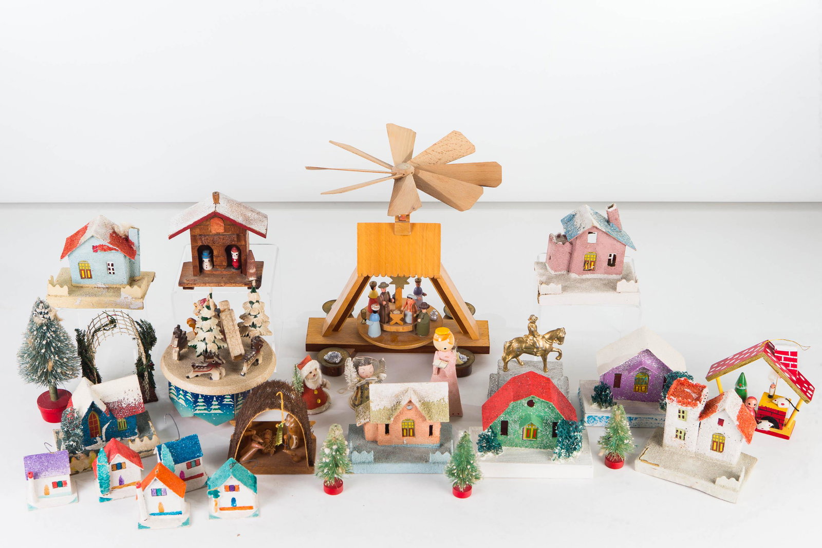 Figural German and Japanese Christmas Grouping: Lot includes a German wooden spinning manger scene with box (9"H), a Japanese wind up rotating music box, a metal man on horse, approximately 12 Japanese paper Christmas houses, two angel figures and 