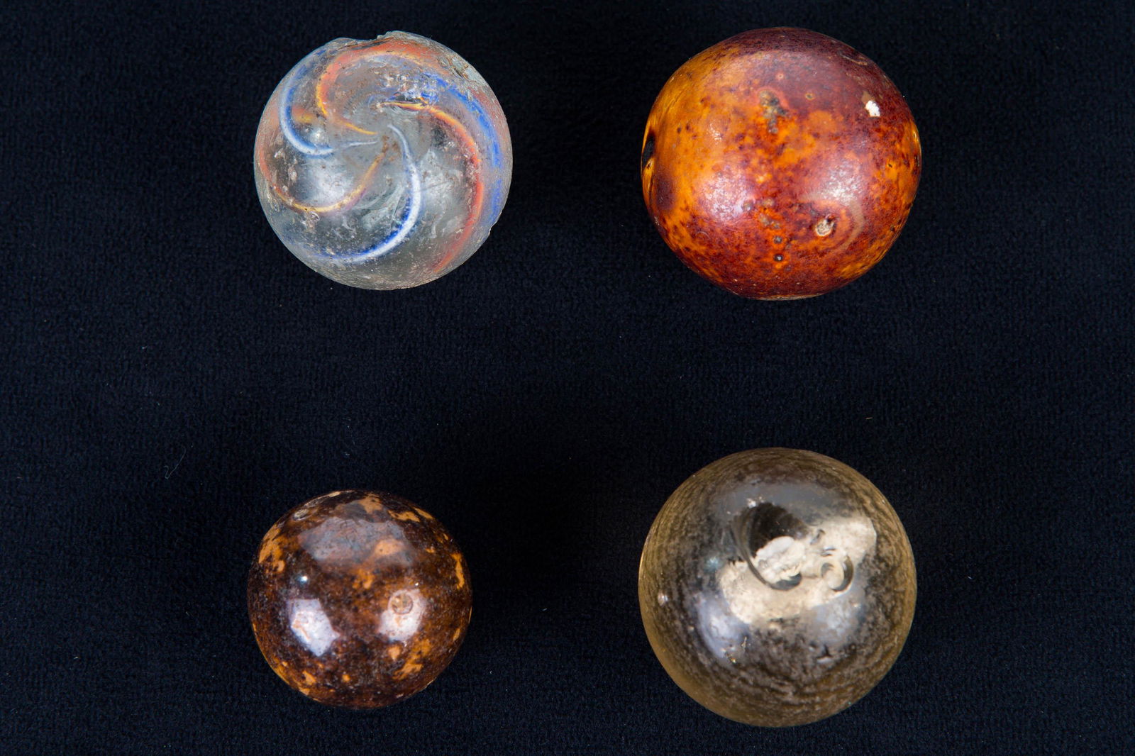 Sulphide and Other Large Marbles: Lot includes sulphide marble with lamb on interior (large chip), latticino swirl marble (chips and scuffs), and two large Bennington clay marbles in good condition.