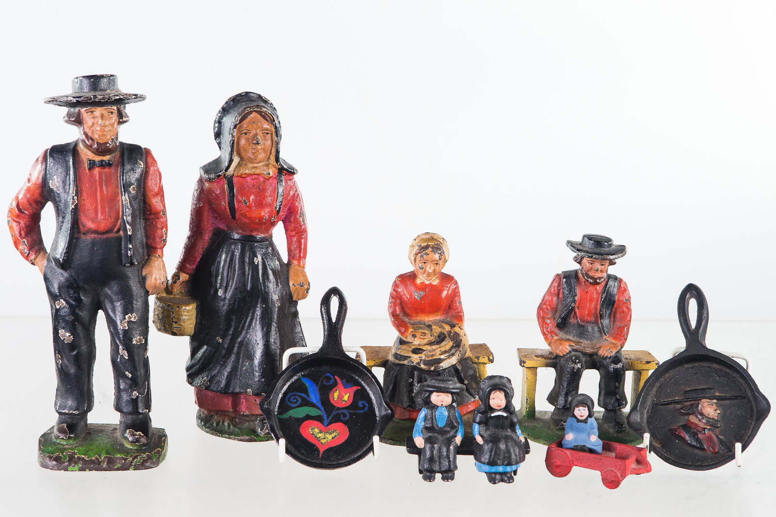 Vintage Amish Cast Iron Figures: Lot includes a Ma & Pa door stops (largest approximately 9"H), and a pair of Ma & Pa bookends. All four pieces are early to mid 20th C, and show common wear to paint. Lot also includes two later minia