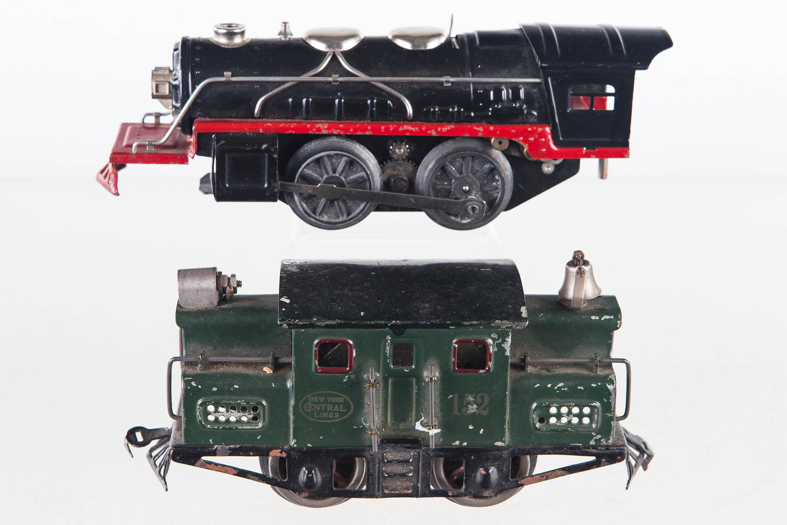 Pre-War Lionel Train Engine and Another: Lot includes NY Central lines pre-war train engine No 152, retaining brass tag on bottom, side, front and back handrails, bell, and couplings. Light bulb mount is lost, shows common surface wear. Lot 