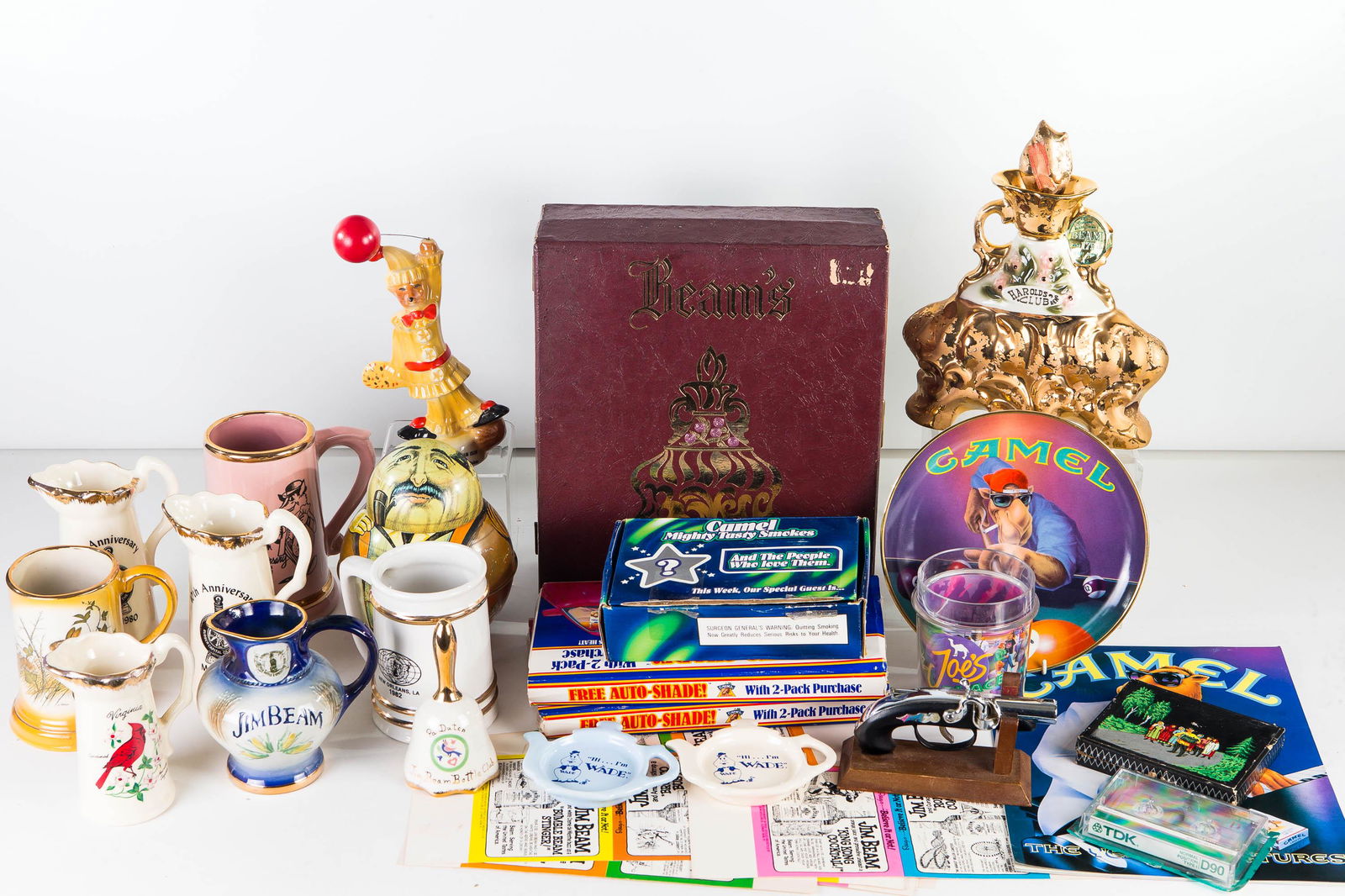 Jim Beam, Joe Camel, & Cigarette Collectibles: Lot includes 175th Anniversary Jim Beam Harold's Club bottle in box, 1980 Jim Beam figure of a fox, Jim Beam related mugs and pitchers, 2 Beam Club Wade Coasters, Ripley's Believe it or Not, Jim Beam