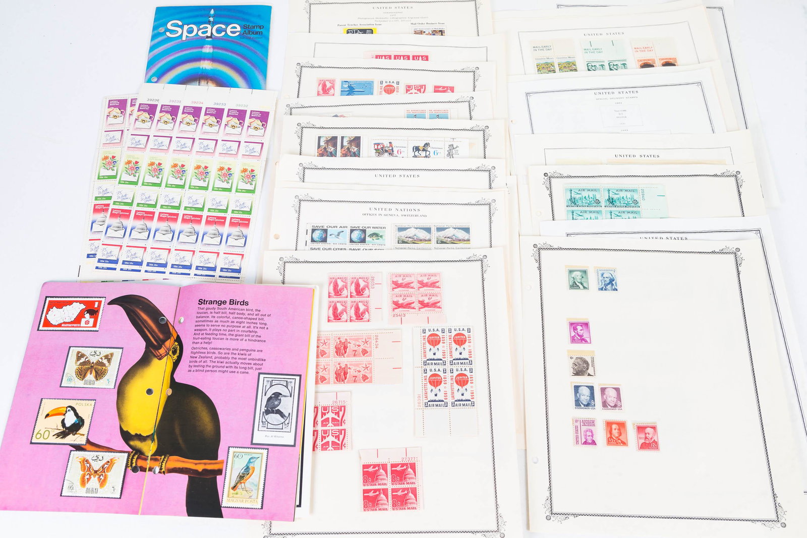 US Uncanceled Stamps and Mini Albums: Lot includes 2 pages of US stamps including 5c to 7c air mail, holiday stamps, Apollo 8 and many others (many in sections of 4), a USPS Butterfly and Bird World stamp album partially full, a Space sta