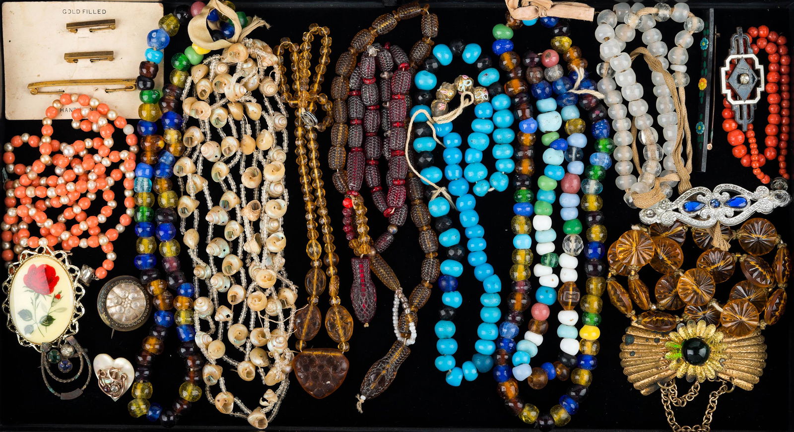 Vintage Estate Jewelry: Lot includes amber and red color serpent glass Art Deco period necklaces, and various other glass and shell necklaces, brooches, and more.