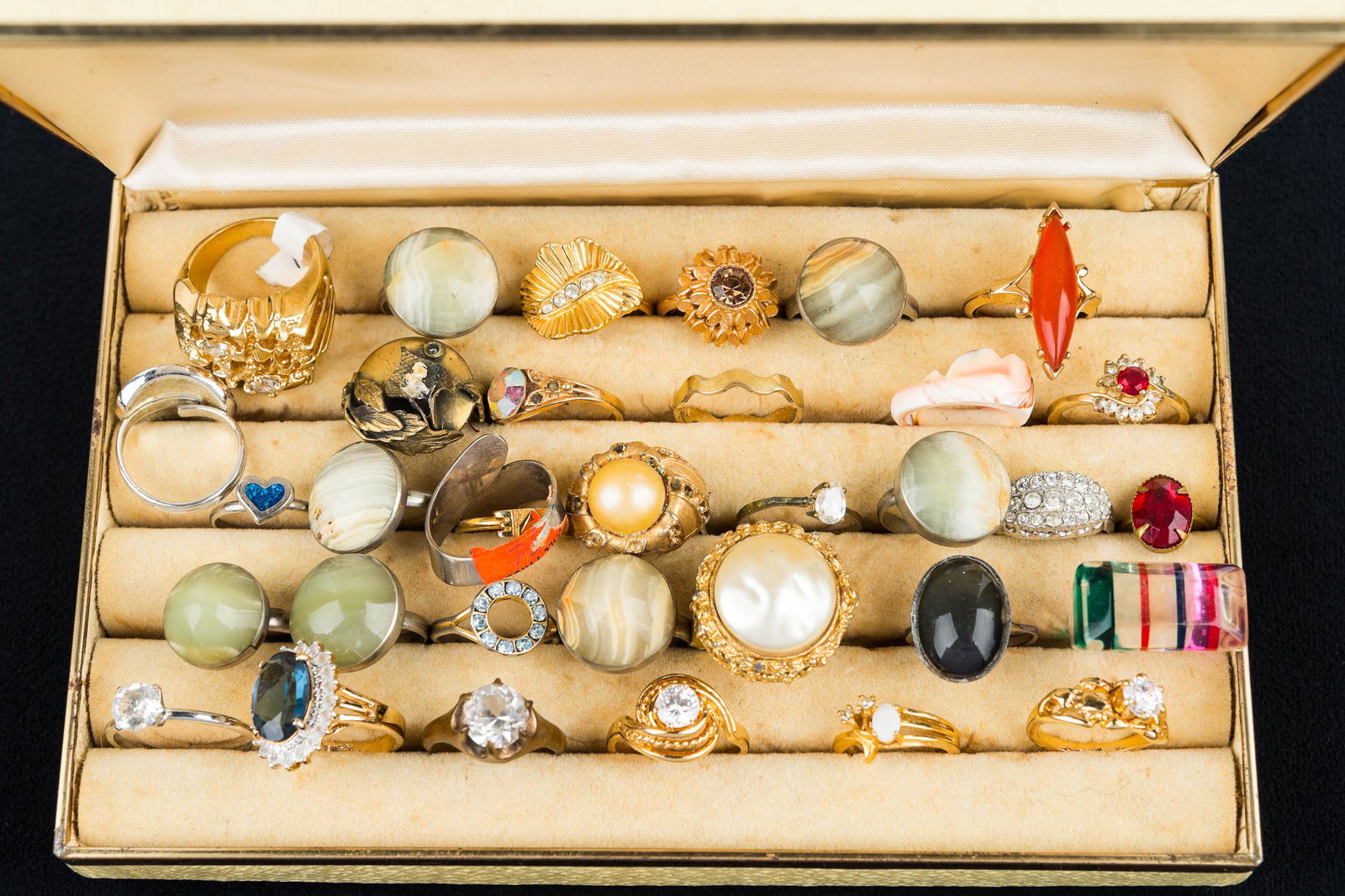 Collection of Estate Costume Rings: Lot includes 34 various sizes and designs, including stone, rhinestone, pearl, and more in vintage ring holder box.