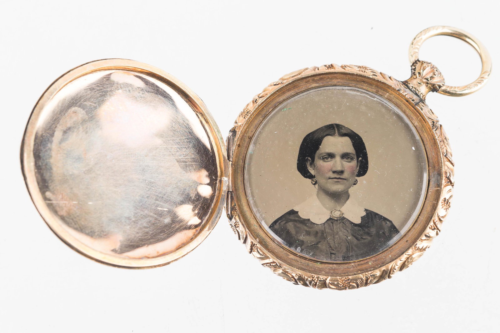 Victorian Daguerreotype Locket: Large, fancy heavy etched castle and sailboat scene, which opens to reveal well dressed lady in her jewelry and finery and gentleman in bow tie.