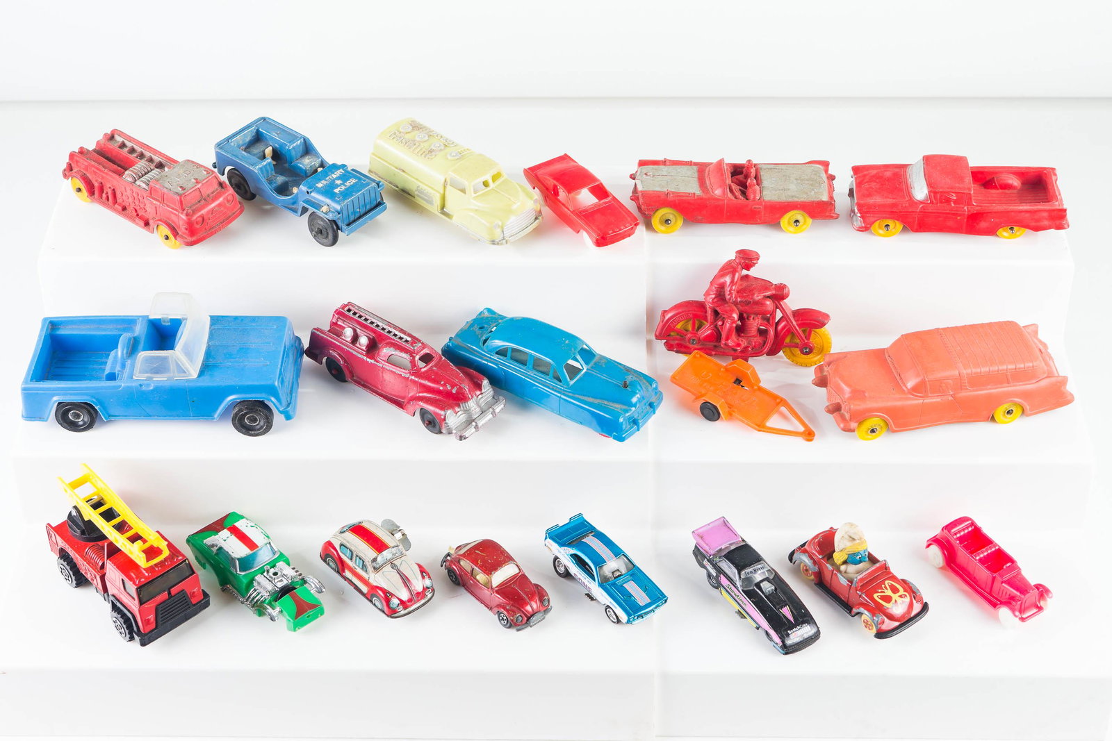 Auburn Rubber Toy and Other Toy Vehicles: Lot includes 5 rubber vehicles, some marked Auburn, a plastic gasoline truck, wind up tin VW Beetle (marked Made in Japan), a Manoil metal firetruck, and various other toys and parts.