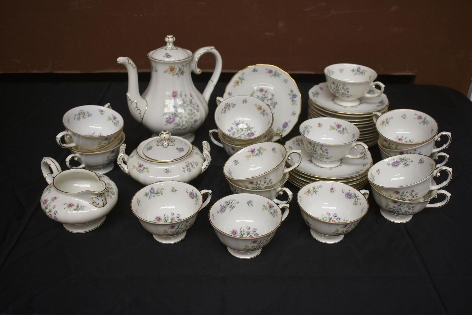 Franconia Millefleure China Tea Service: Includes 18 cups and 19 saucers, creamer, covered sugar, and teapot (8"H) with lid. Gold rim and floral pattern, marked Franconia.