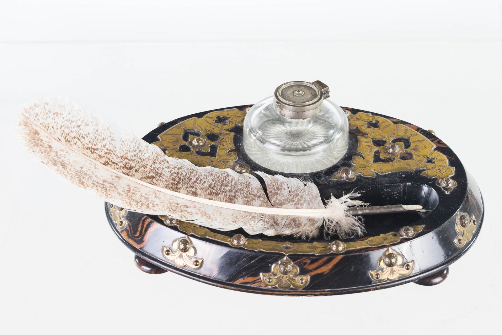 Ebonized and Brass Victorian Inkwell: Item measures approximately 12"L x 9"D. Ebonized wood with decorative brass overlay. I retains inkwell with lid and it has original feet. Dates to late 19th/early 20th C.