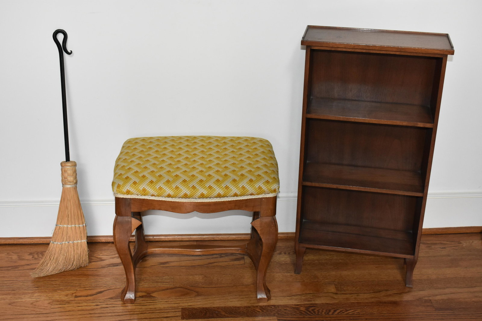 Footstool, Broom, and Bookshelf: Lot includes an upholstered Victorian style stool, a bookshelf and a wrought iron and straw broom. Items are available for pick up from our Chestnut Hill / Philadelphia location by appointment.