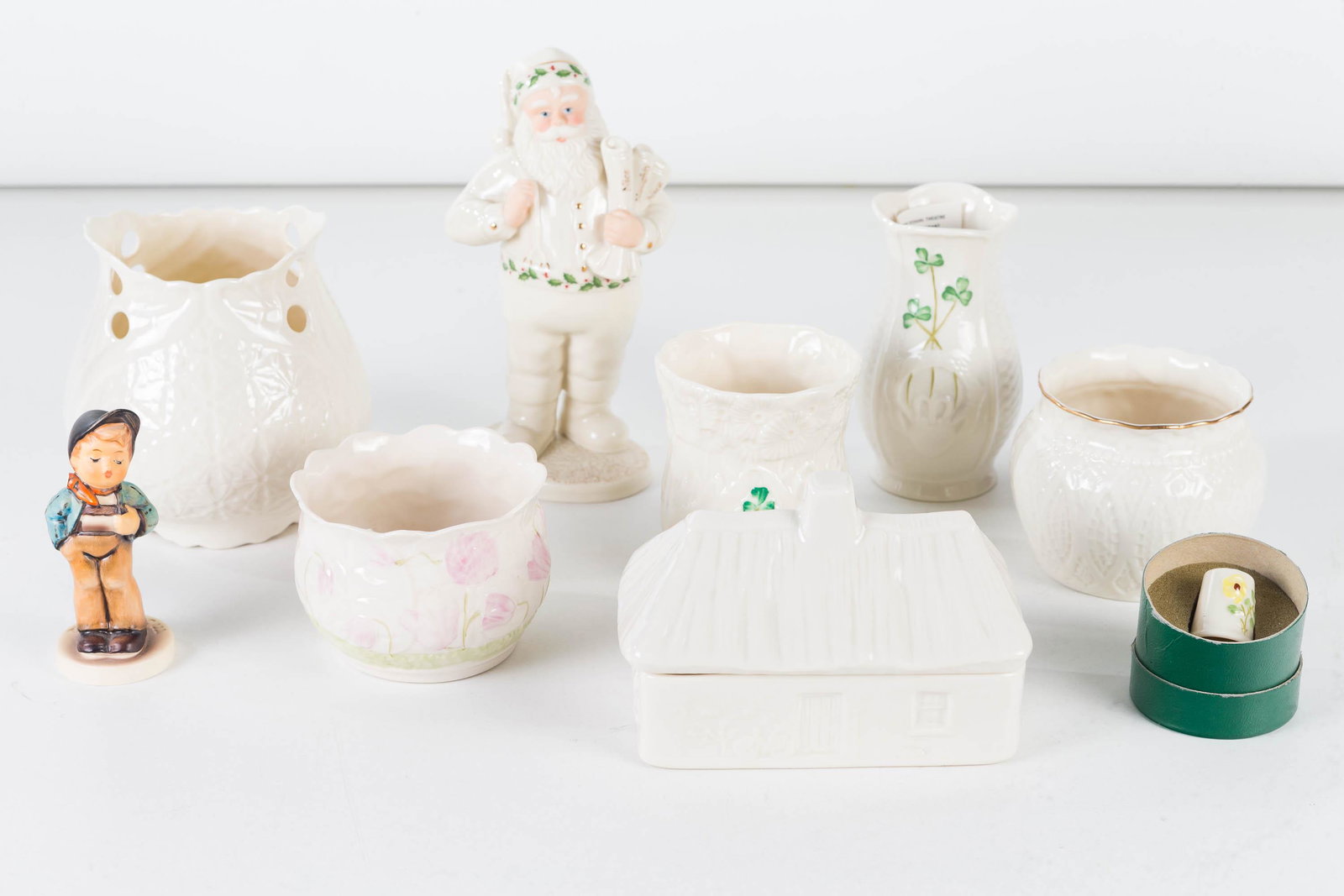 Belleek and Lenox items: Lot includes 7 pieces of Belleek including a covered jar in the form of a cottage (marked Kilmore Cottage 1999 Event Piece), 5 various Belleek vases and a Belleek thimble, a Lenox Santa (7"H).
