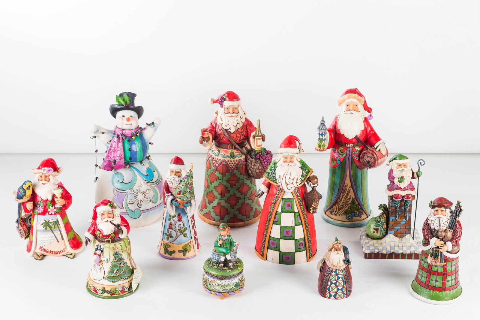 Jim Shore Santa Collection: Lot includes 7 Santa's (largest approximately 10"H), a snowman with faux Christmas lights, and St. Patrick's Day covered pin box.