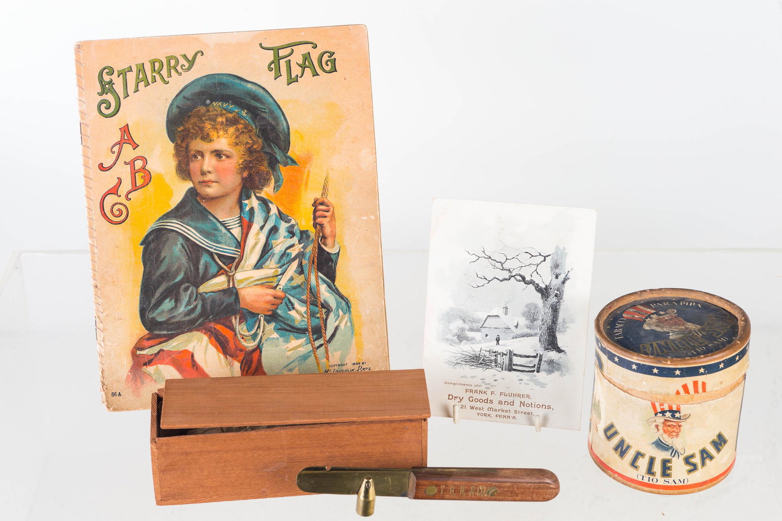 Patriotic and Other Advertising: Lot includes cardboard Uncle Sam pipe tobacco container, Starry Flag ABC book (copyright 1899), a dry goods advertising from York, PA, and a pipe tool from T.F.R. & Co. with box.