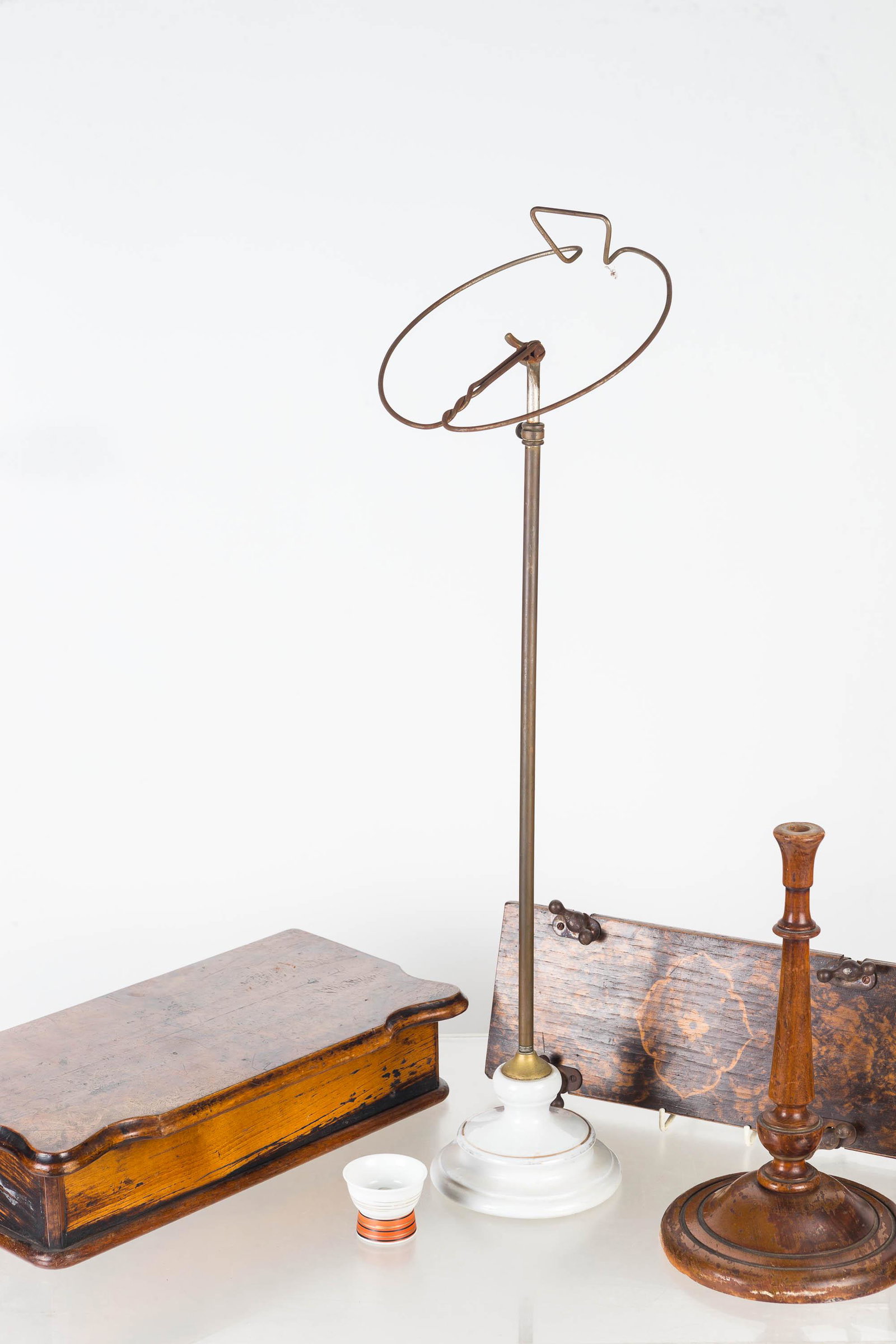 Mixed Haberdashery Grouping: Lot includes an adjustable hat rack with porcelain base (21"H at lowest point), a Victorian decorated tie press, a wooden collar box, a standing pin cushion base, and a peek-a-boo nudie eyeglass.