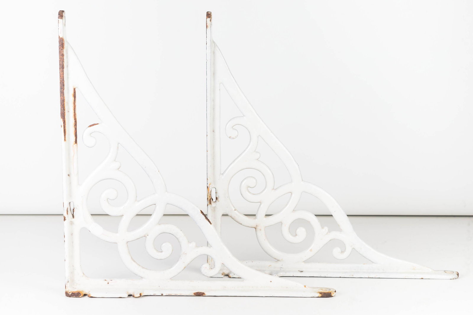 Pair of Vintage Enameled Shelf Brackets: Each approximately 15"H x 15"D. Enameled over cast iron, show some surface wear.