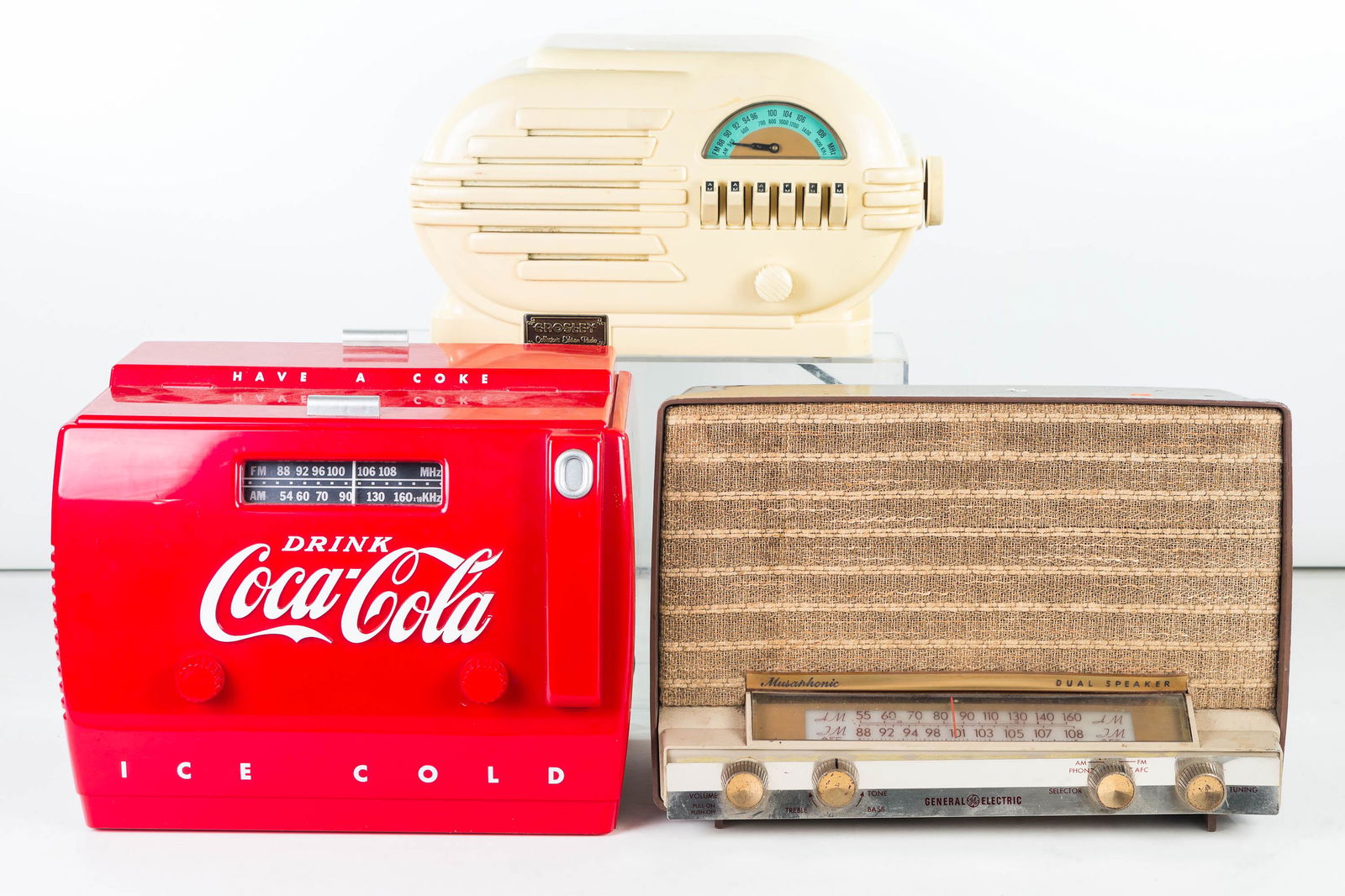 Coca Cola and Other Radios: Lot includes a contemporary radio in the form of a Coca Cola ice cooler (Model No OTR-1949, produced for Coca Cola), a Crosley Collectors Edition Radio (Model No 0353), and a 1960s General Electric Mu