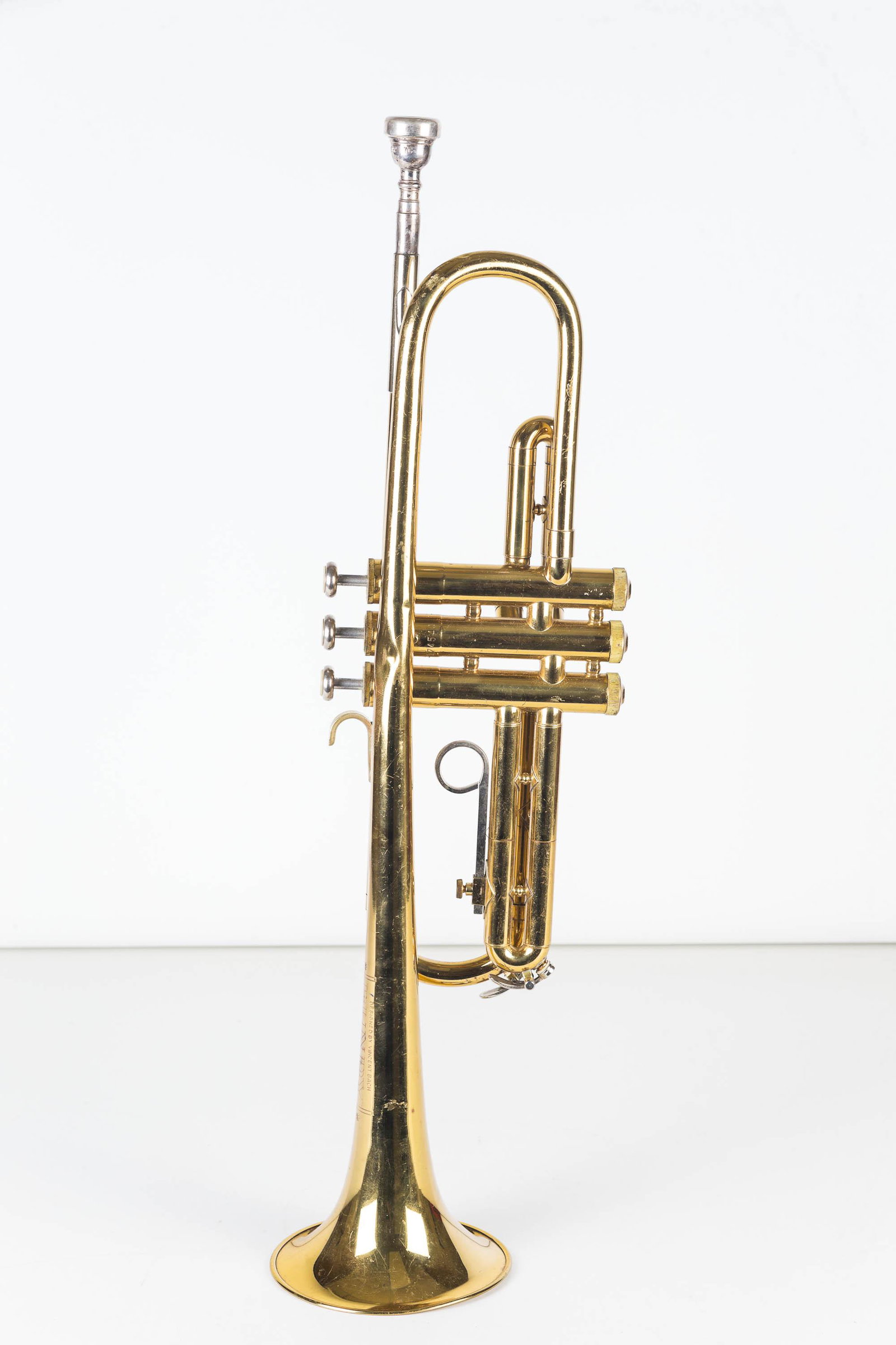 Vincent Bach Bundy Trumpet: Item measures approximately 21.5"L, including mouth piece. Keys work freely, surface is in overall good condition, but it has one dent on opposite side of horn near center. Serial No 174544.