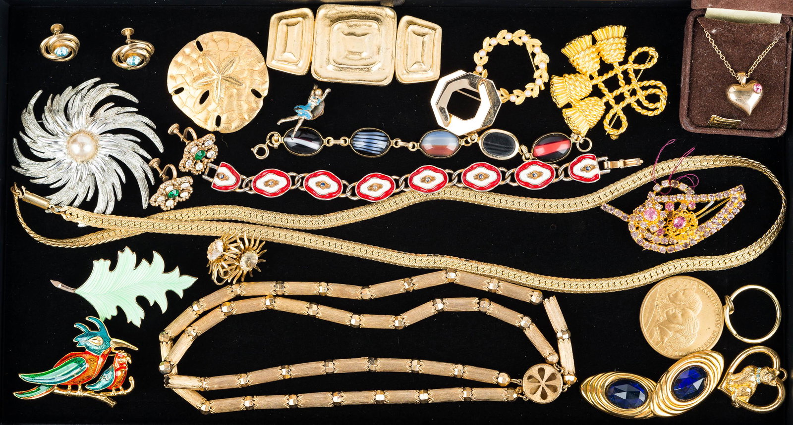 Mixed Costume Jewelry: two quality gold tone chains, post Modern style brooch marked Les Bernard, sand dollar brooch, red and white enameled bracelet, colorful rhinestone leaf pin, and other gold tone and enameled jewelry.