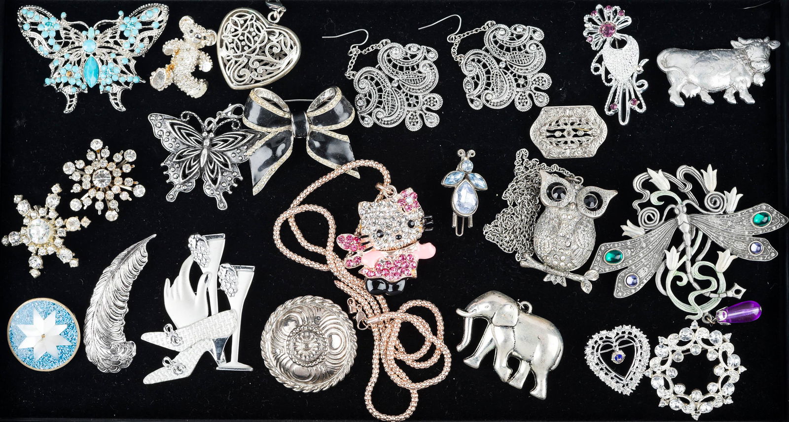 Rhinestone and Silver Tone Costume Jewelry: flexible rhinestone Hello Kitty pendant on chain, pewter owl on chain, large pewter Nouveau style dragonfly marked JJ, other figural animal pendants, rhinestone snow flake pins, blue rhinestone insect