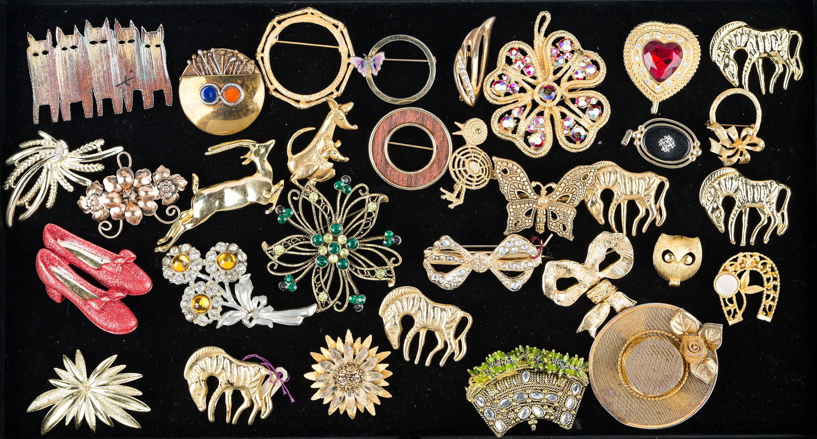 Figural and Other Gold Tone Jewelry: various figural animal pins, butterfly pin, large gold tone four leaf clover with colorful rhinestones brooch, floral brooch with green and lemon rhinestones, enameled ruby slipper brooch marked AJC, 