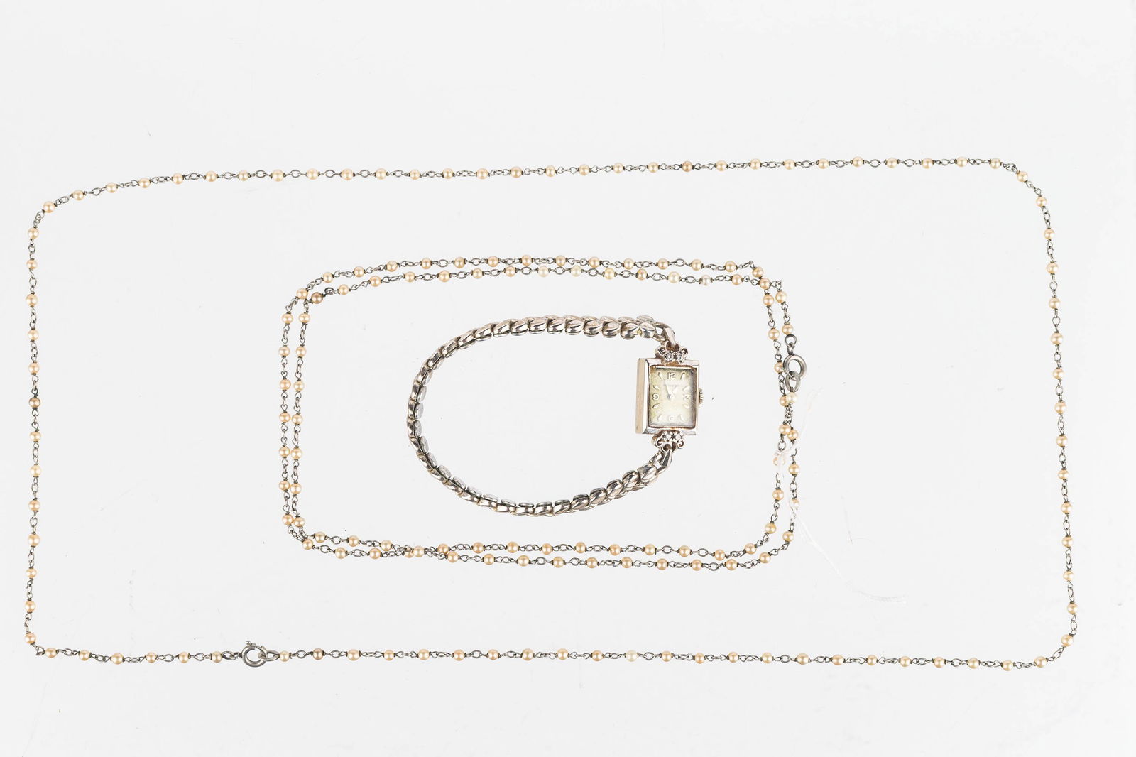 Vintage Platinin and 14K Gold Wristwatch: Lot includes two delicate necklaces marked PLATININ with beads (appear to be pearls) necklaces, each is 27" long, plus a 14K gold vintage ladies Movado wrist watch with 4 diamond accents (tested) and