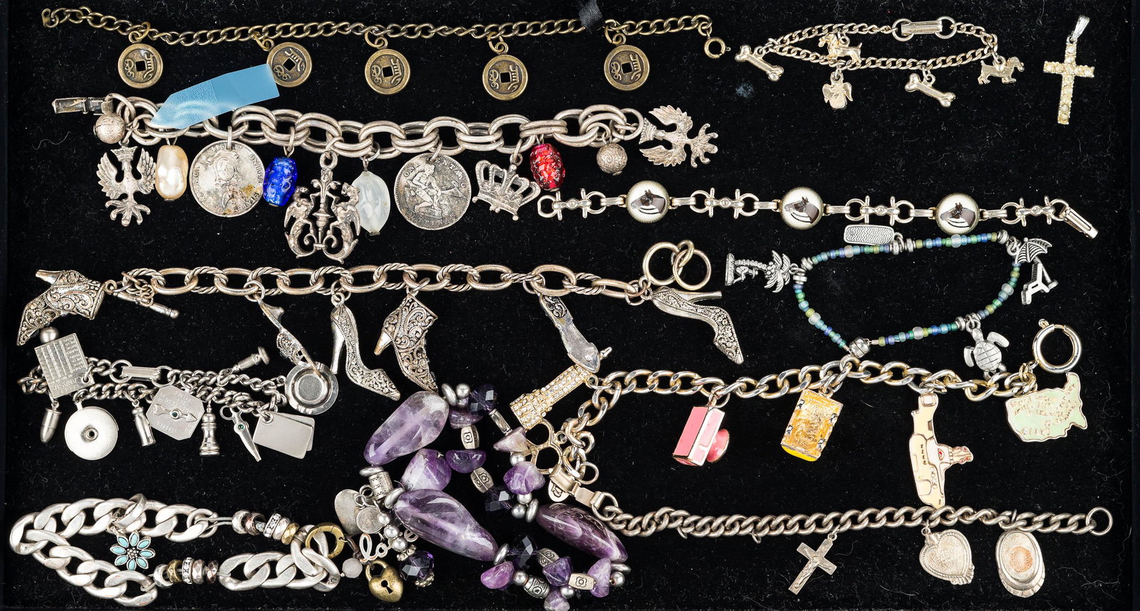 Collection of Charm Bracelets: charm bracelet with European style charms and coins, Asian coin bracelet, charm bracelet with enameled car, camera and other items, dog and bone charm bracelet, a large purple chunk stone bracelet, an