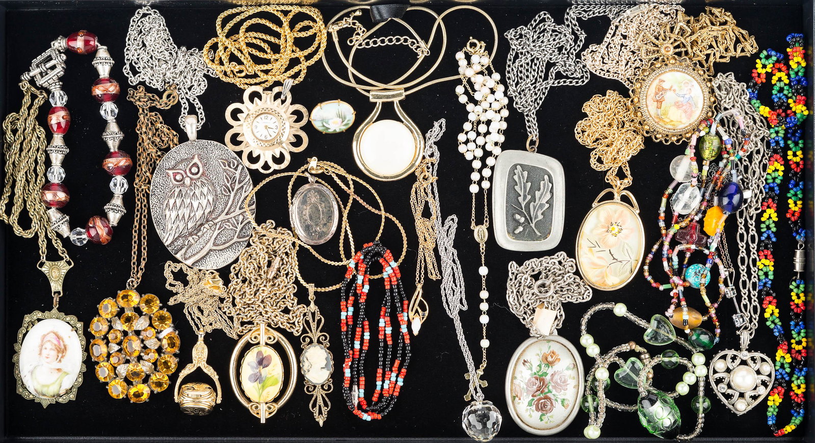Necklaces, Bracelets, and Pins: large amber rhinestone pendant on chain, Swarovski crystal strawberry pendant on chain, blue cameo pendant, an oval locket with three compartments, other lockets, a pendant watch on chain, and other c