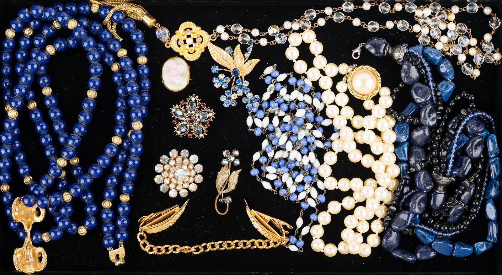 Necklaces and Pins: large blue beaded necklace with double ram horn locket, blue and white beaded necklace, multi-strand chunk beaded necklace and others, leaf pin with multicolor blue rhinestones, small floral brooch ma