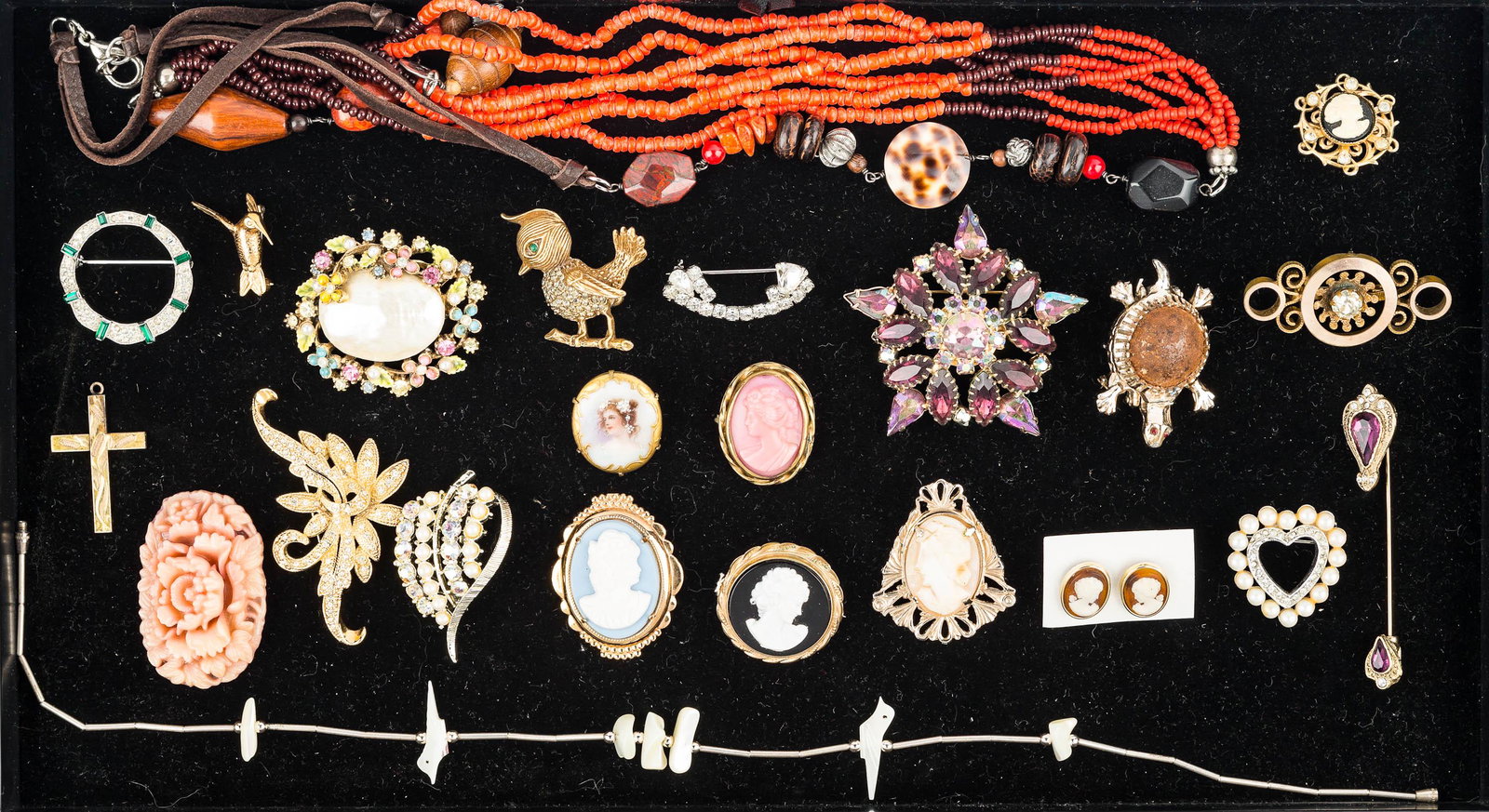 Cameos, Rhinestones, and Costume Jewelry: Four cameo pins, a pair of cameo earrings, rhinestone and shell brooch marked Artco, a turtle locket, stick pin with purple rhinestones, figural bird pins, mother of pearl fetish necklace, beaded cora