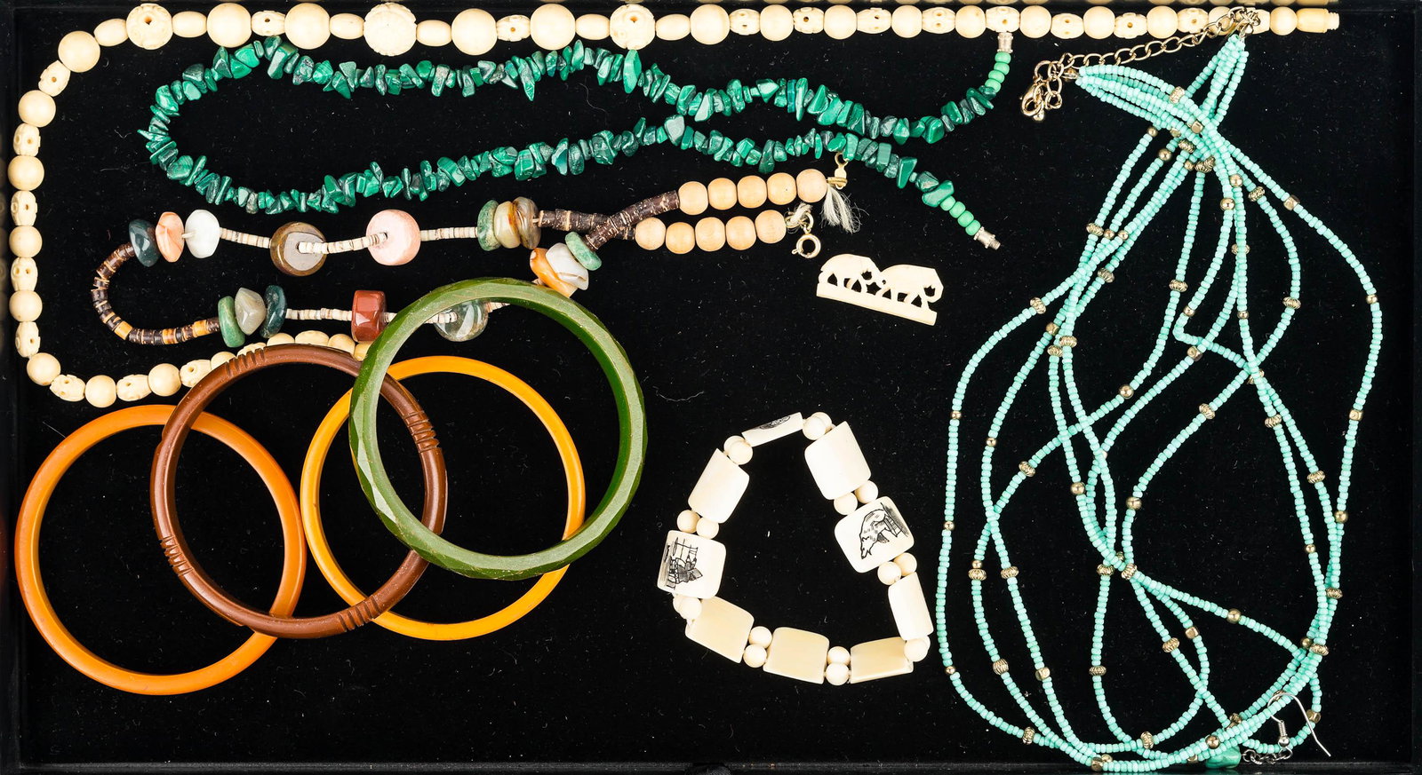 Bakelite Bangles and Beaded Jewelry: Four Bakelite bangles, delicate beaded turquoise style necklace, carved beaded necklace, bracelet with scrimshaw sections, green chunk necklace, and related items.