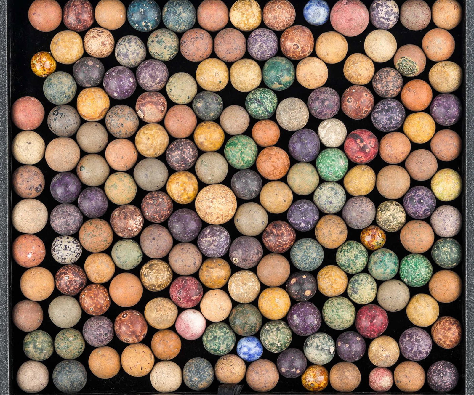 Colorful Clay Marbles: a large selection of clay marbles of different sizes and colors.
