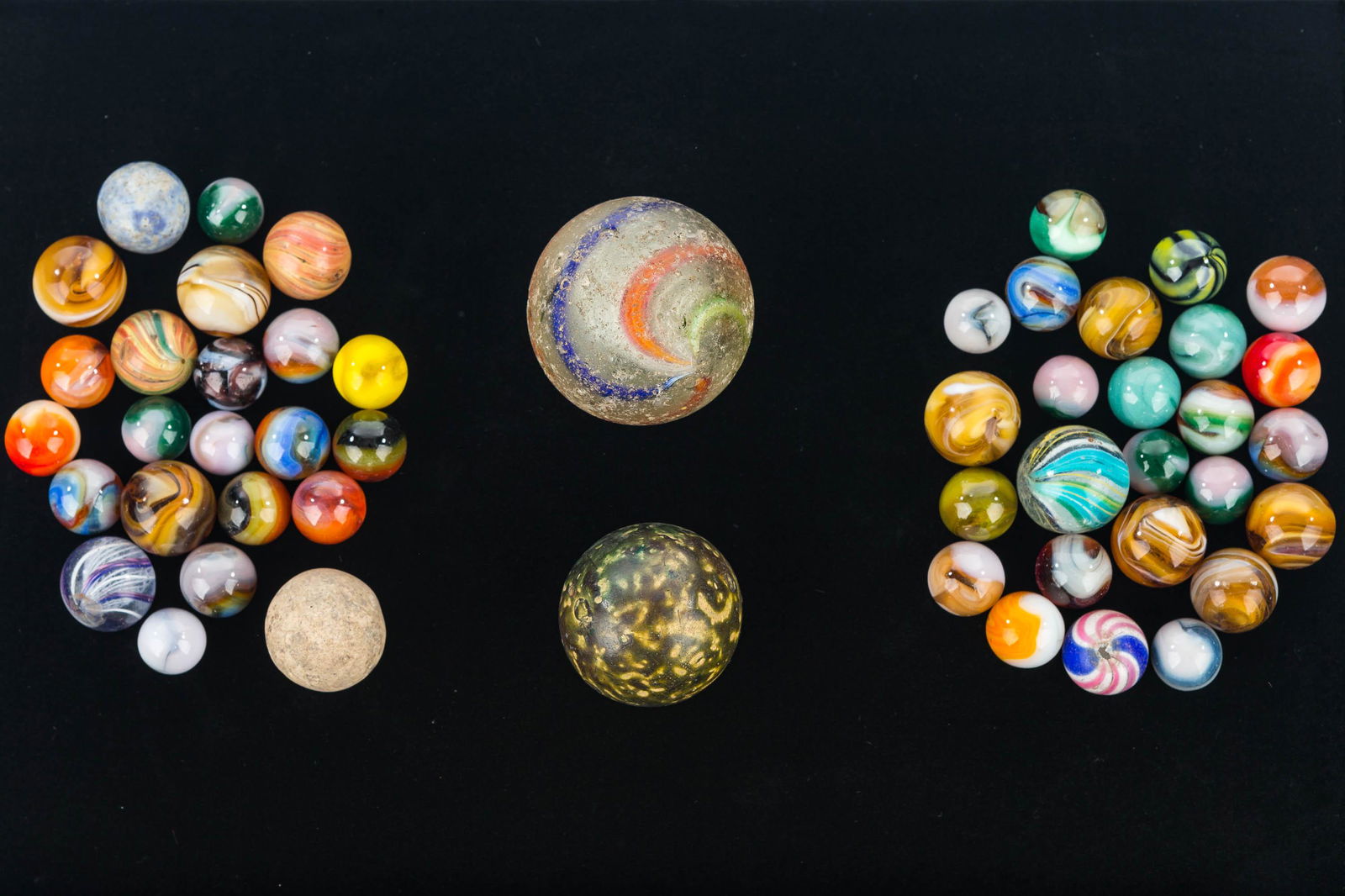 Latticino Swirl and Colorful Marbles: massive latticino swirl marble (1.75" diameter, surface shows wear and will need tumbling), clean latticino swirl knuckler, large green clay knuckler, purple and white latticino swirl, agate and other