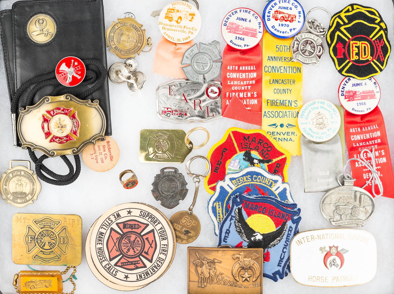 Firemen and Shriner Memorabilia: two brass firefighter belt buckle (one with enameling), firefighter patches and medals, a vintage Jr. Fire Marshall ring with elk, enameled Shriner belt buckle, brass Shriner belt buckle, and other fi