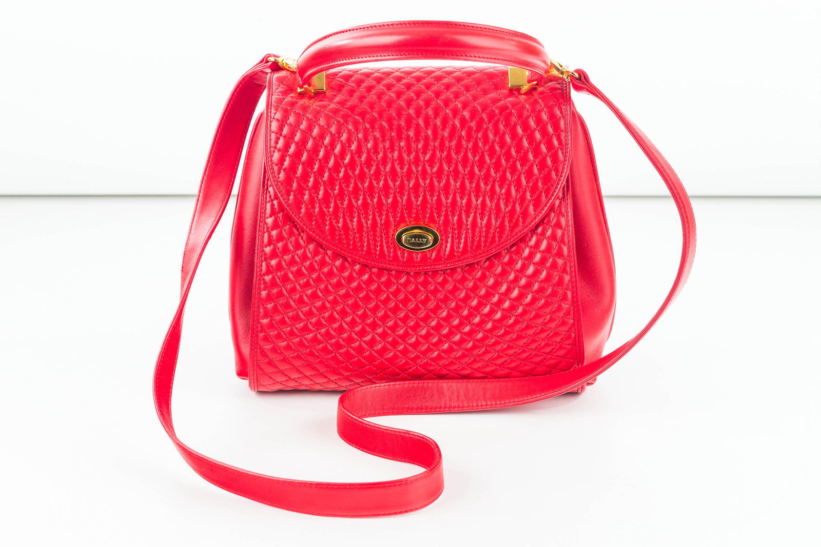 Bally Soft Quilted Lambskin Hand/Shoulder Bag: This barely used beautiful red purse is approx 10" x 8 1/2" x 5" covered in quilted lambskin front and back, unquilted leather sides, envelope expansion. It has 4 gold tone bottom protector buttons, g