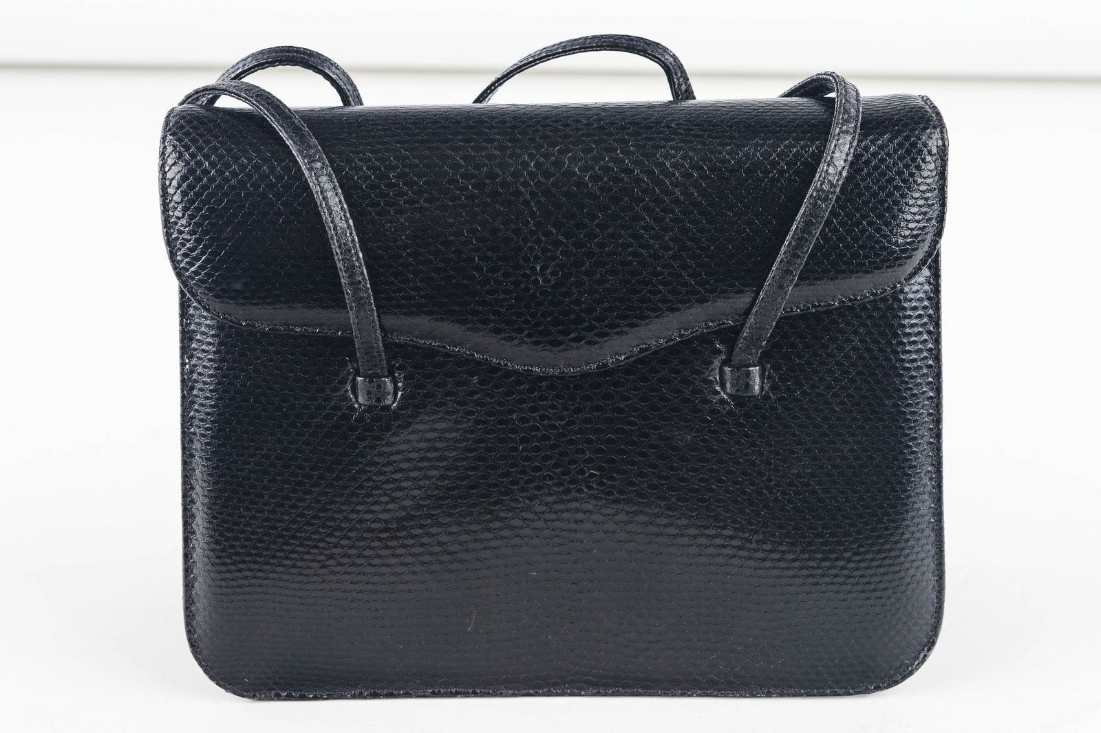 Judith Leiber Black Lizard Embossed Handbag: This beautiful black lizard embossed evening bag is approx 7 1/2" x 6" x 2 1/2" with 2 leather 1/4" wide hand straps measuring approx 19" from end to end. Envelope style expanding sides, sports a meta
