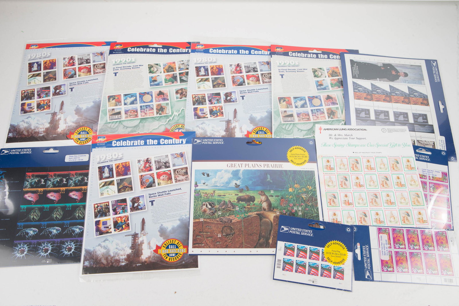 US Postage Stamp Sheets on Card: Lot includes 12 sets of stamps, 11 are in original packaging. Stamps include the 80's 33c, Deep Sea Creatures 33c, the 90s 33c, Great Planes 34c, Chinese New Year 34c, and others.