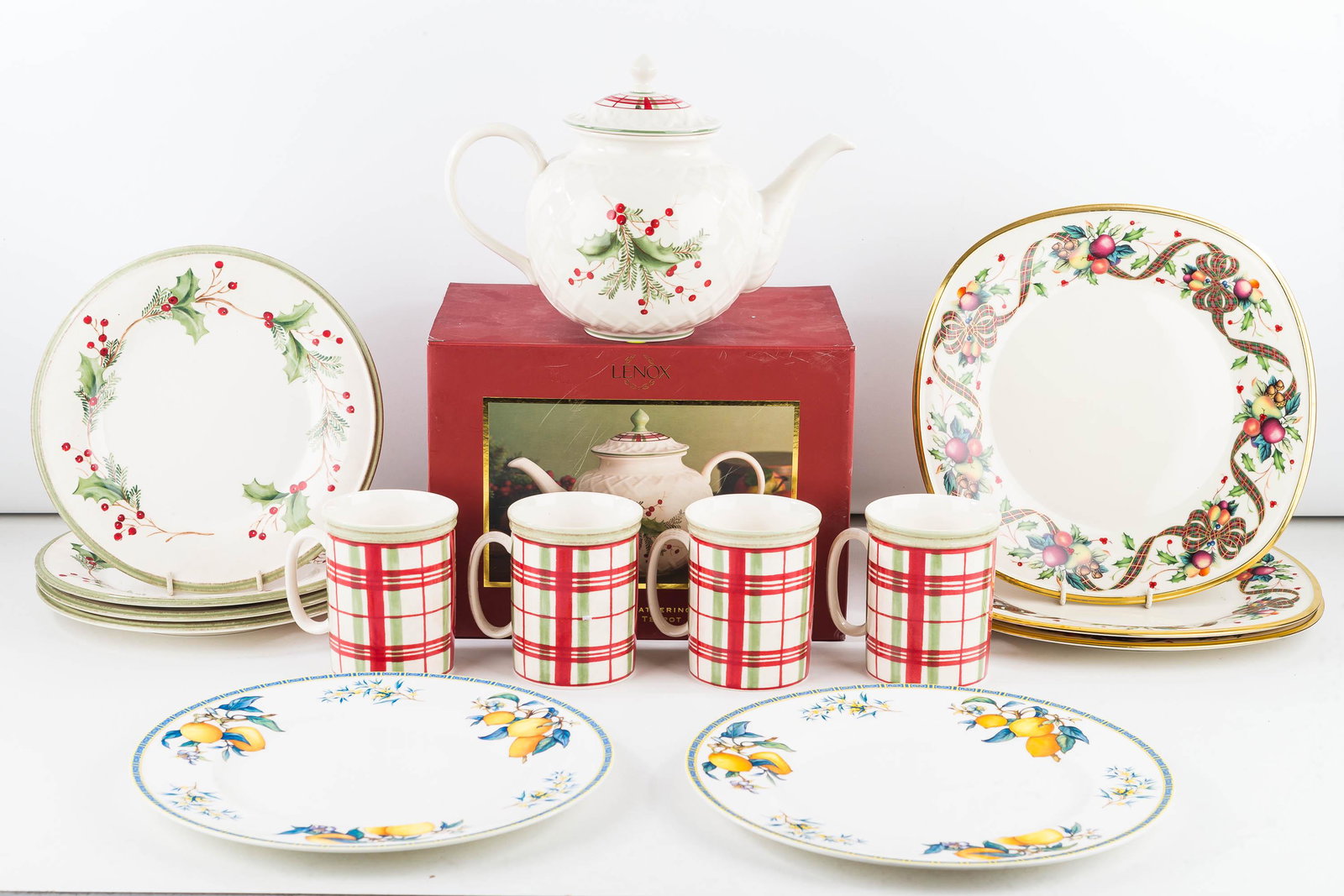 Lenox and Wedgwood China: Lot includes Holiday Gathering carved teapot in box, 4 Holiday Plaid coffee mugs, 4 Holiday Gathering salad plates, 3 Holiday Tartan rectangular dinner plates, and 2 Wedgwood citron pattern dinner pla
