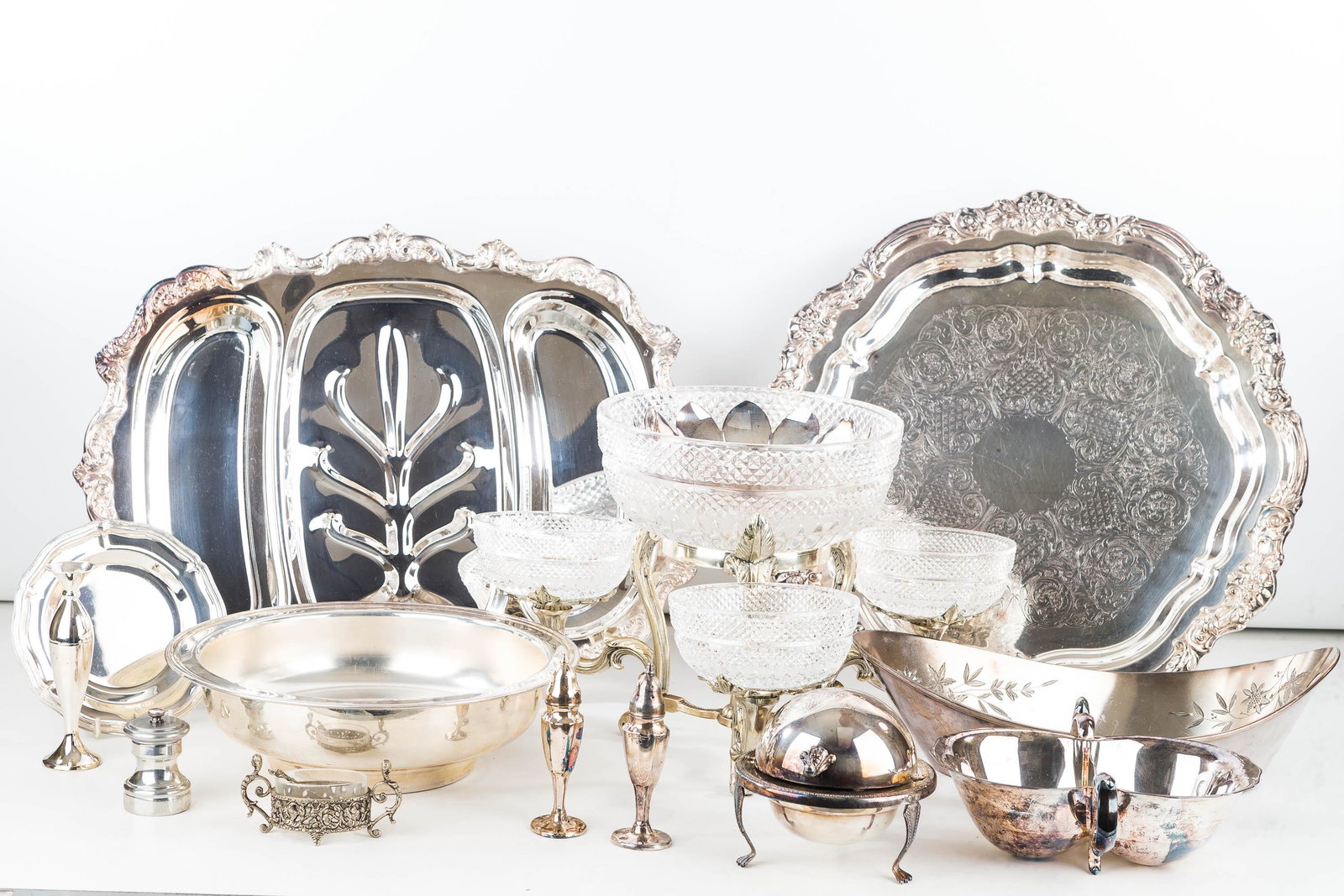 Silver Plated Trays, Bowls, and Footed Servers: Lot includes a footed circular tray (16.5" dia), a meat platter, an orb butter dish, an epergne with pressed glass bowls, a coffee pot with warmer missing toggles, and various other items.