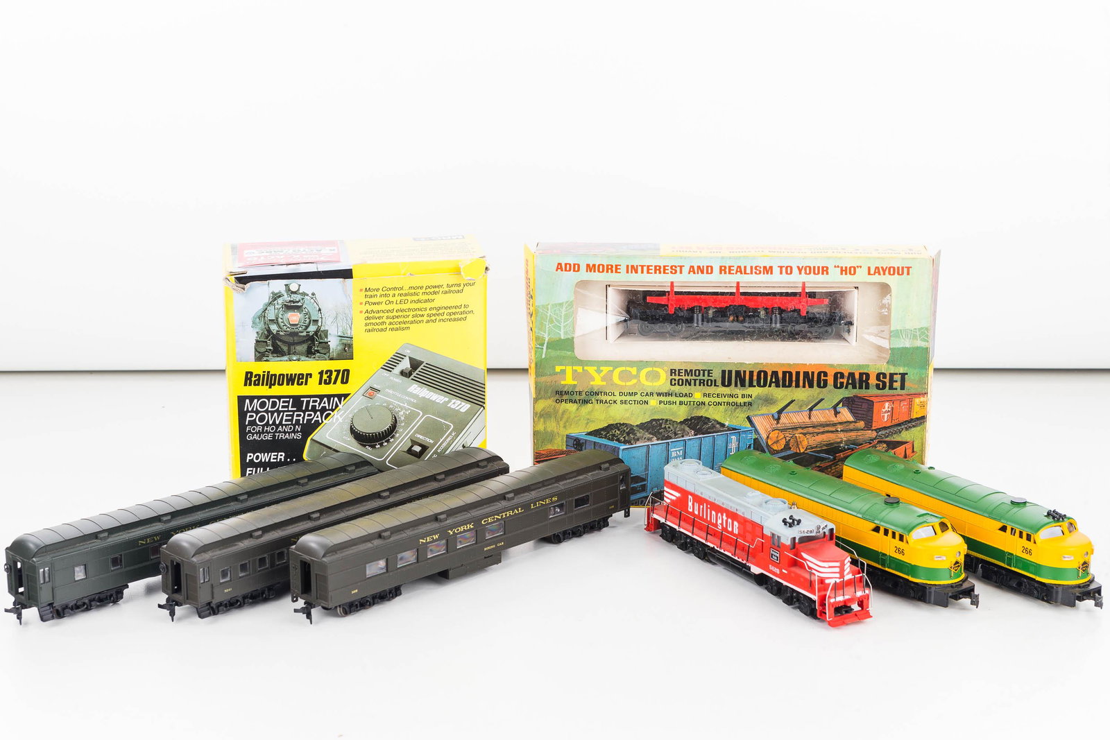 HO Gauge Trains and Accessories: Lot includes Tyco Burlington Engine, Tyco unloading car set in box, a Rail Power 1370 model train power pack in box, 2 Tempo Redding Lines engines, and 3 NY Central passenger cars.