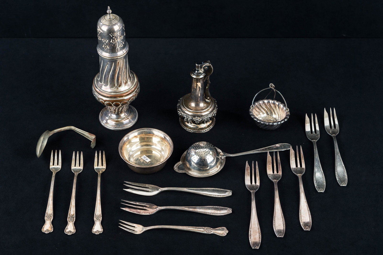 Muffineer and Other Vintage Silver Plate: Lot includes muffineer (8"H), tea strainer, various condiment forks, a hanging strainer, and a silver plated Ronson table lighter.