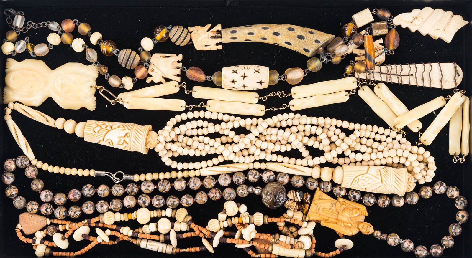 Carved Bone Jewelry Grouping: Lot includes wire wrap and beaded necklace with carved elephants and geometric with wooden and glass pieces, carved bone totem on bone and gold tone chain, beaded carved bone necklace with carved elep