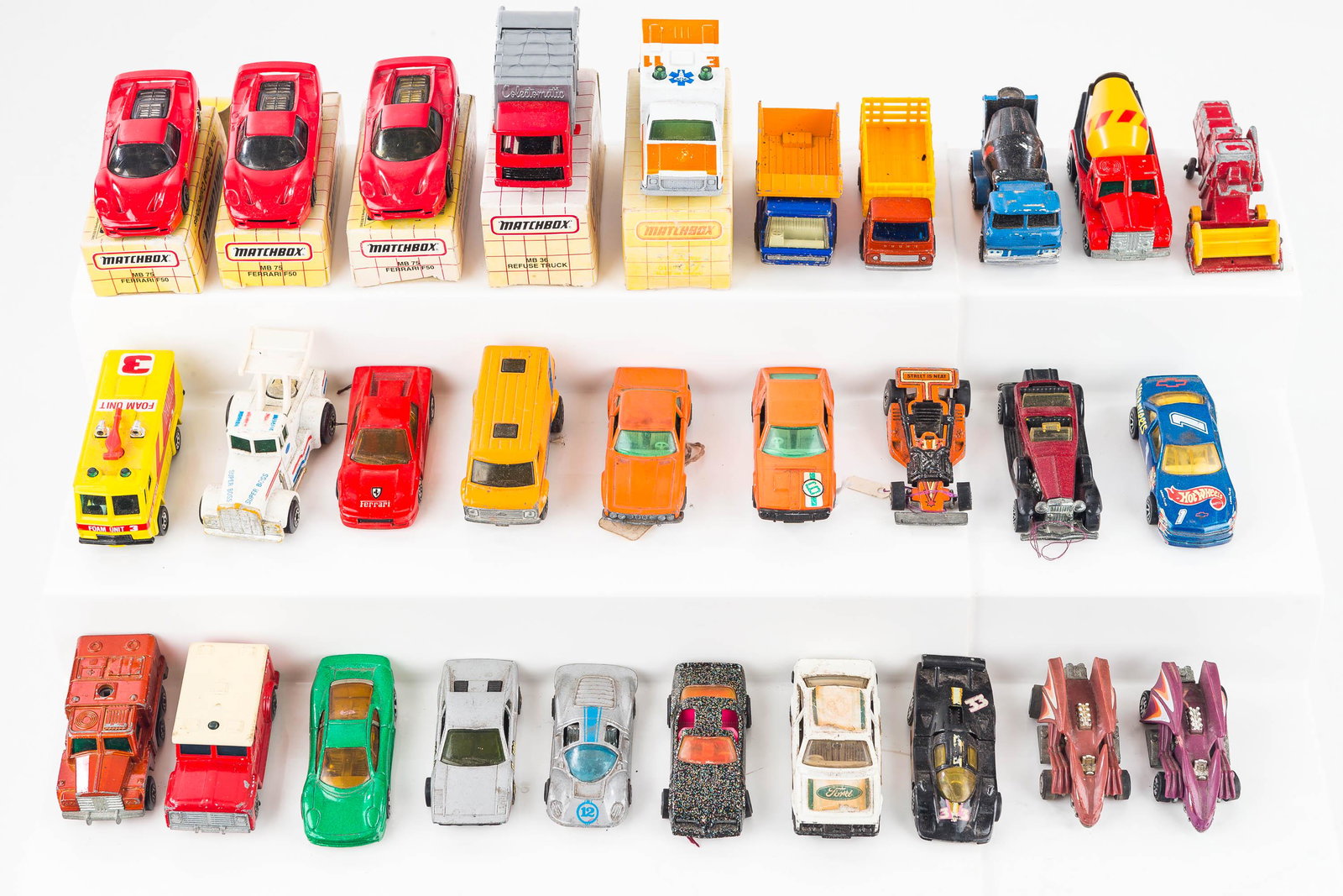 MatchBox and Hot Wheels Grouping: Lot includes black metallic Firebird, two Hot Wheels with bat wings, Ferraris in original box, and various others. Surface conditions vary.