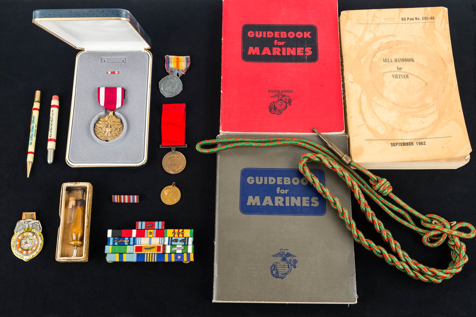 Military Medals and Books: Including WWI Service medal, WWI navy medal dated 1916, French WWI Verdun medal dated 1916, bar pins, US marines guidebooks, 1962 Vietnam handbook and two bullet pencils. Some sterling.