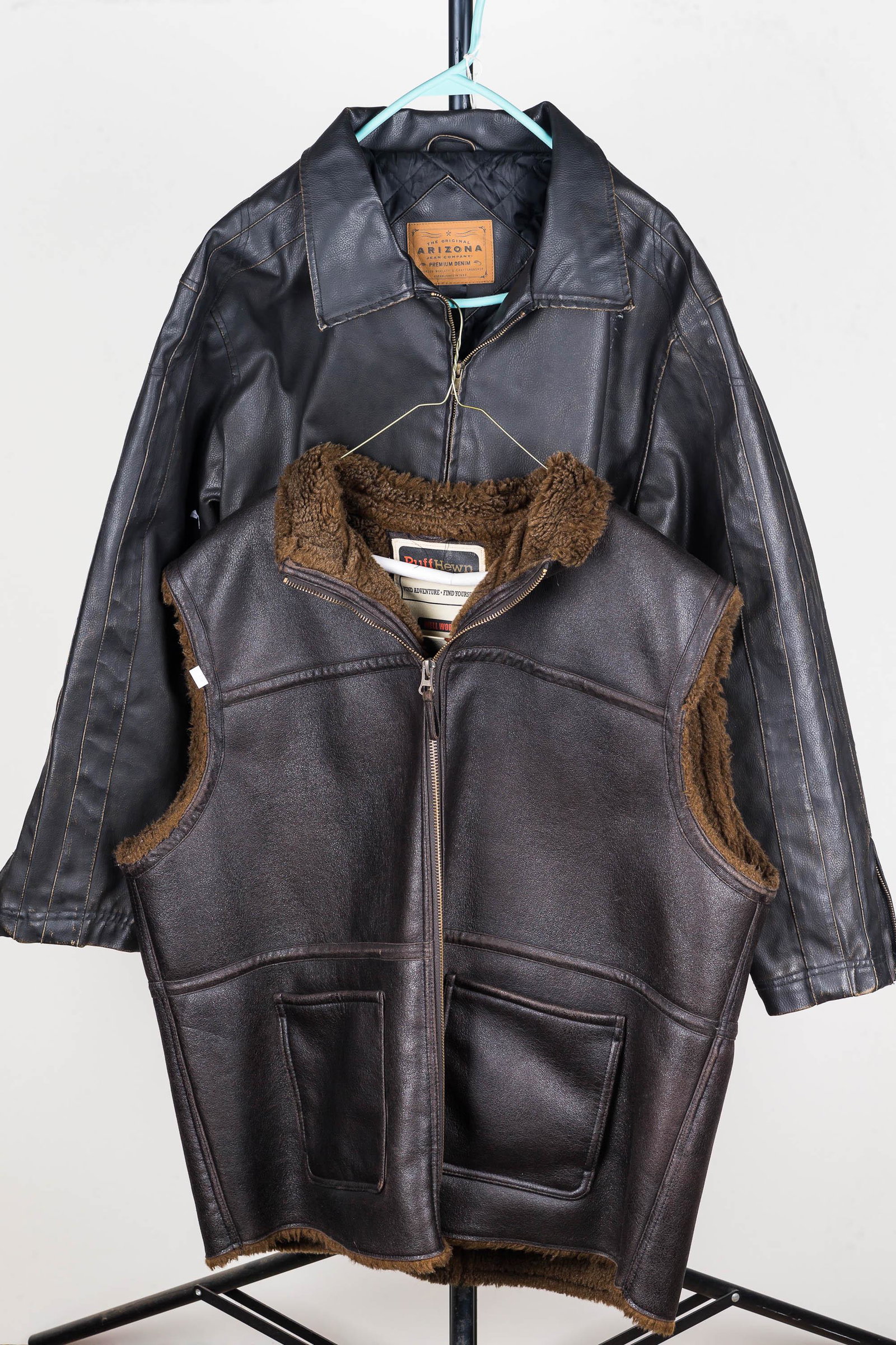 Arizona Leather-Style Jacket and Ruffhewn Vest: Arizona brand faux leather jacket with permanent lining. Black with decorative stripped shoulders. Lot also includes a Ruffhewn faux leather vest with permanent liner.