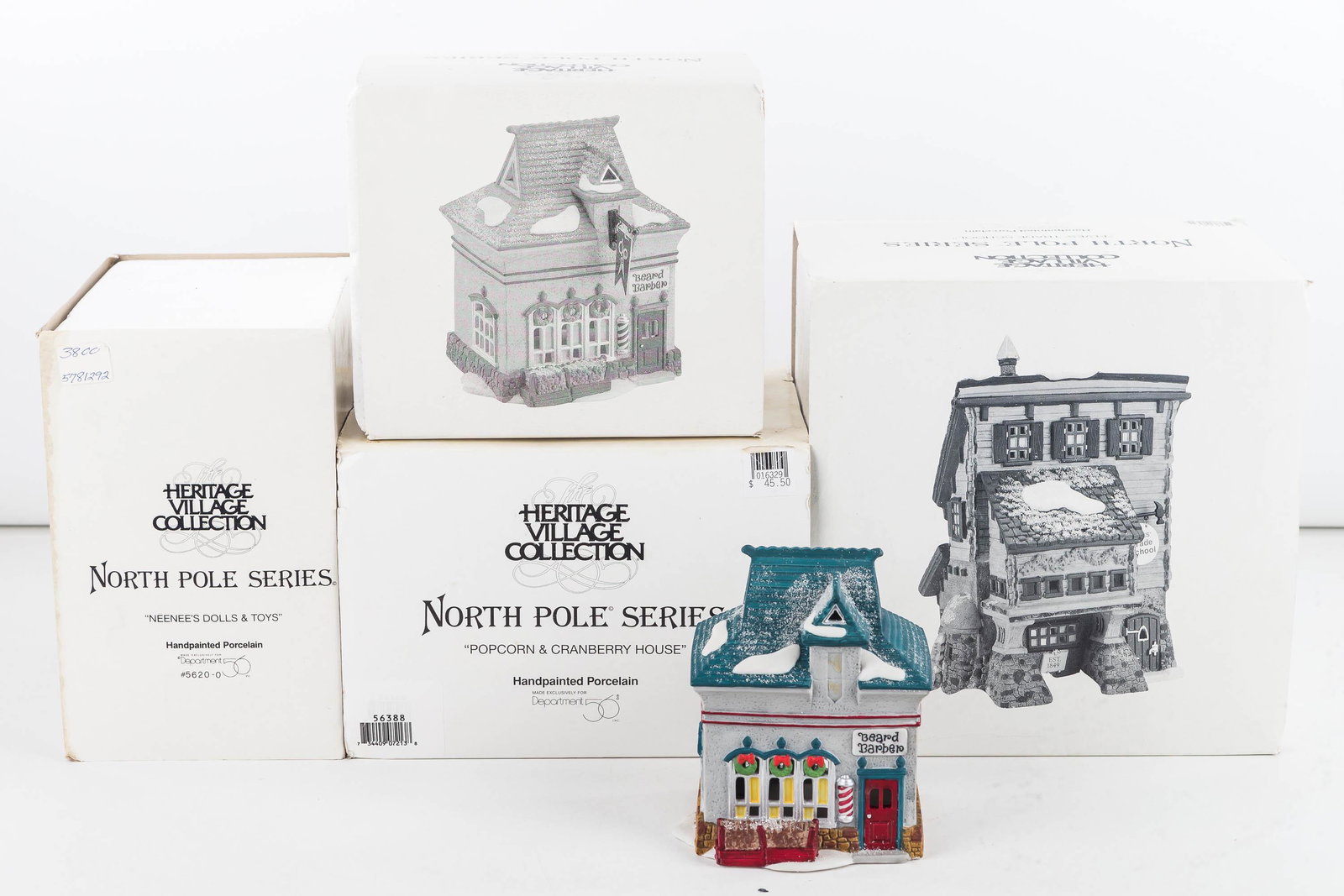 Department 56 Collection/North Pole Series: Four pieces including Elves trade school, Beard barber shop, Nenne's doll and toy shop and Cranberry and popcorn shop. In original boxes.